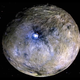 Dwarf planet Ceres shown in false color, with Occator Crater visible.